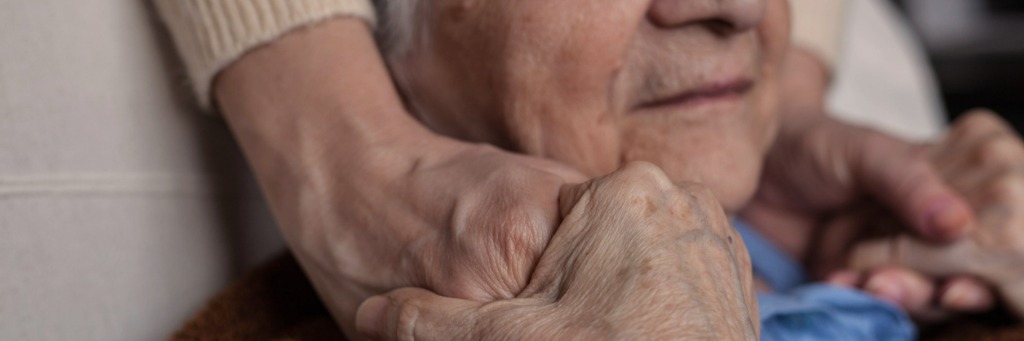 Elderly person holding hands.
