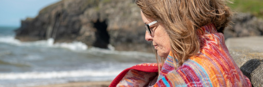 Woman wrapped in colourful blanket.