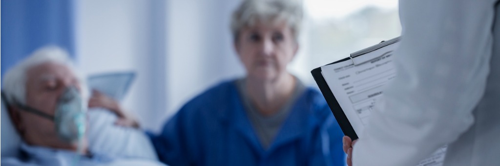 Doctor with clipboard near patient.
