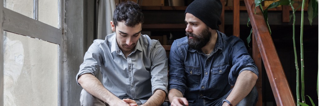 Two men sitting and talking.