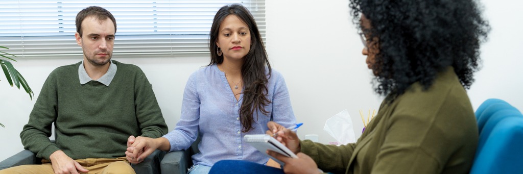 Couple holding hands in counselling.